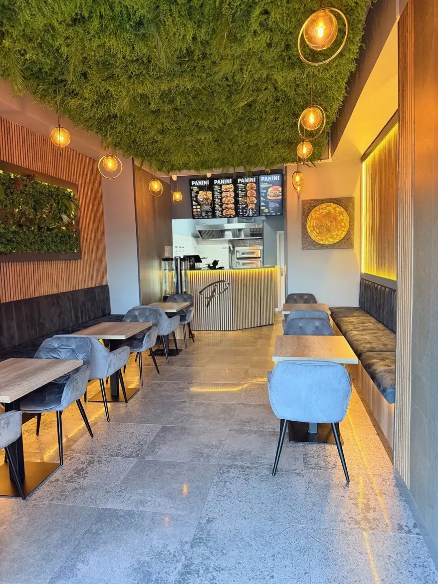 Interior Panini Station cu perete verde și iluminat cald — Craiova